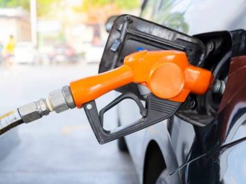 fuel nozzle filled car with fuel, car being filled gasoline at gas station, Pumping gasoline fuel in black car at gas station , Gas pump nozzle.